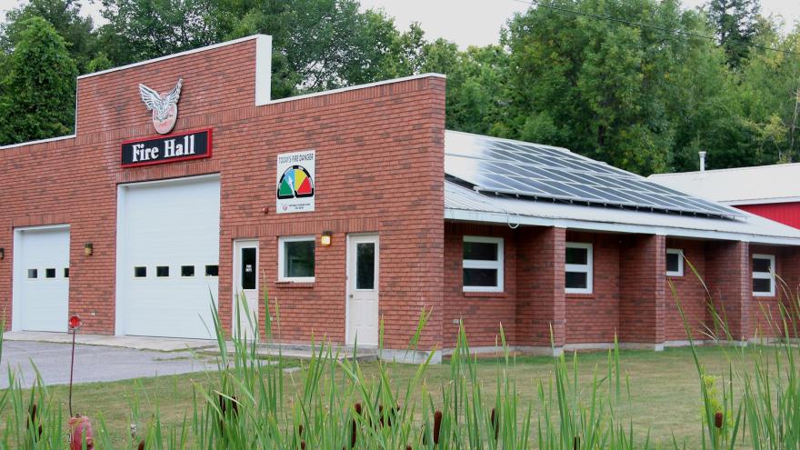 Fire station with red brick and white garage doors.
