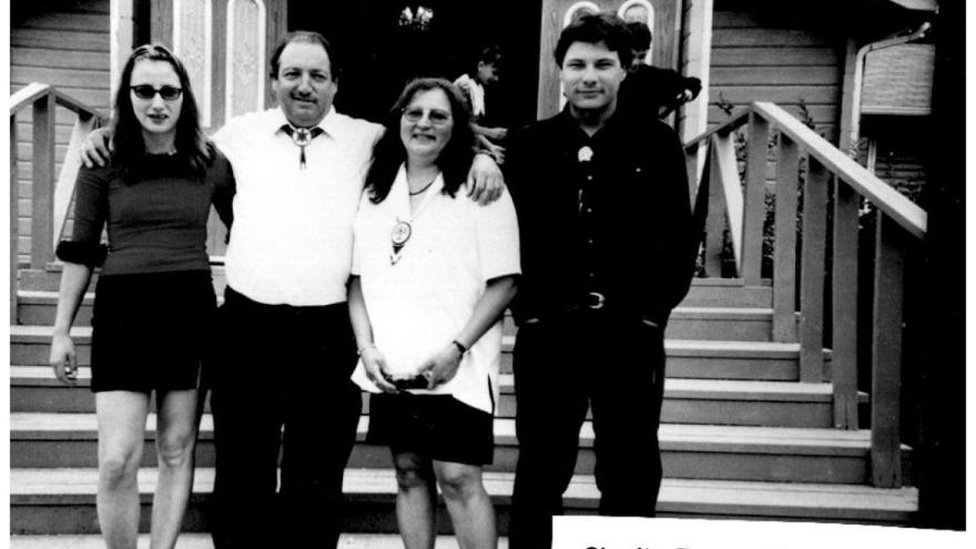 Black and white photo of four people standing on stairs.