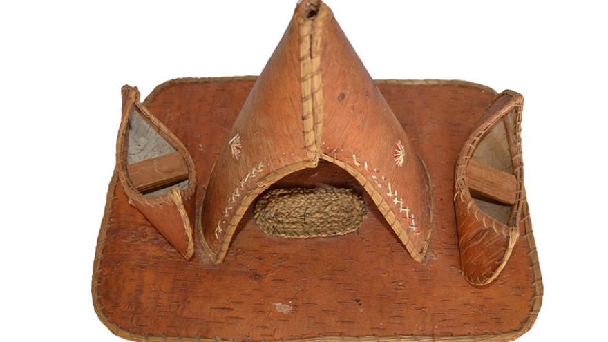 Traditional leather teepee and canoes.