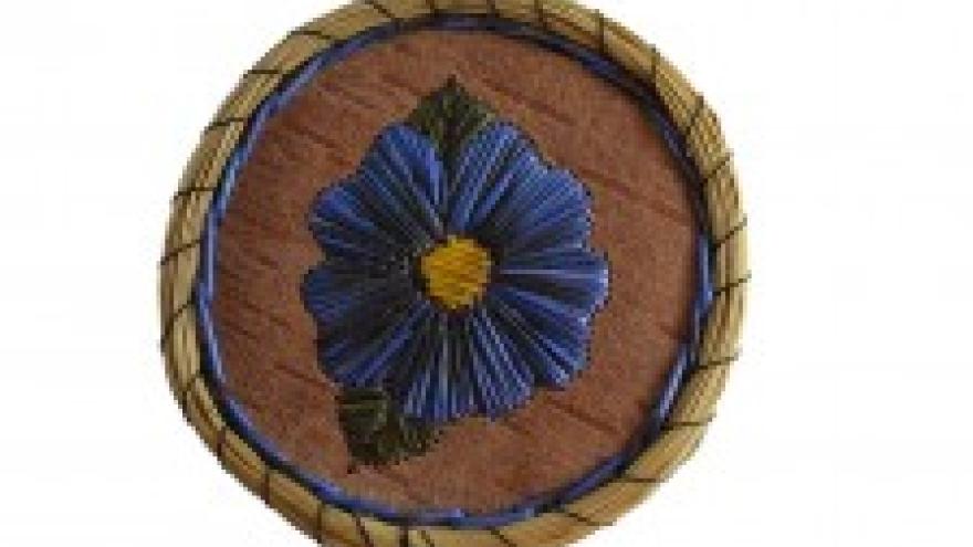 Woven basket lid with blue flower design.