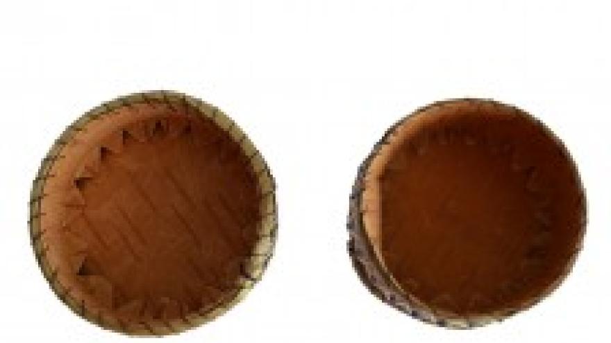 Two empty woven baskets on a white background.
