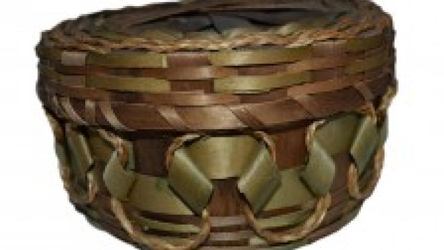 Woven basket with intricate green and brown pattern.