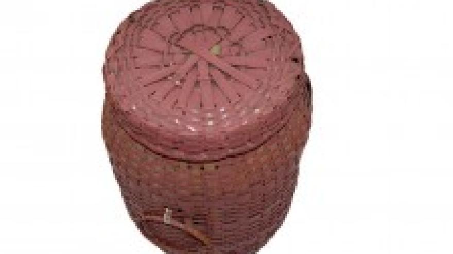 Woven pink basket with circular lid and handle.