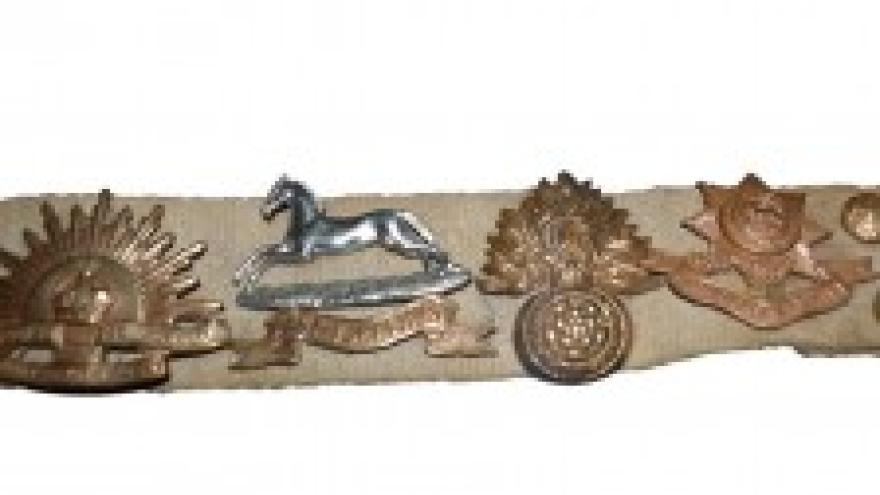 Military insignia on a beige strap, featuring various emblems.