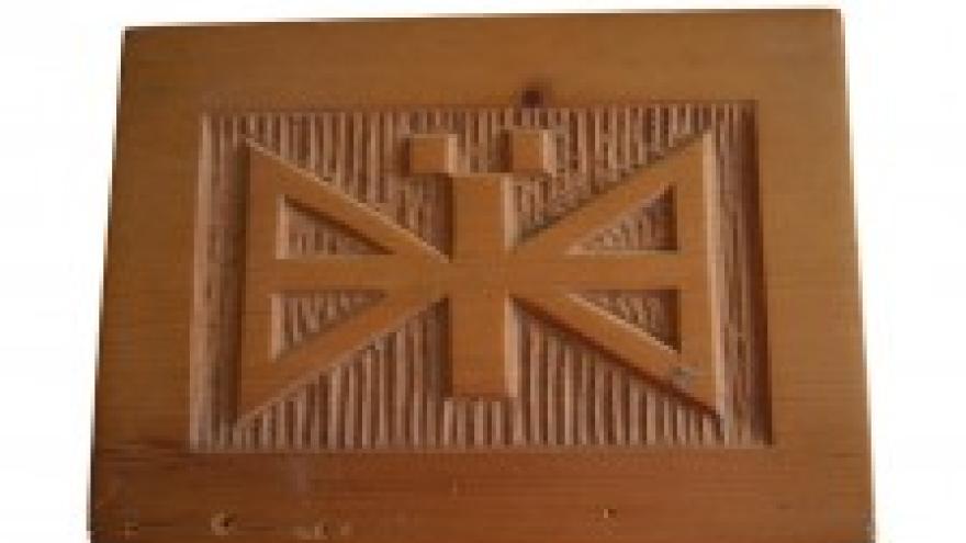 Carved wood panel with abstract geometric design.