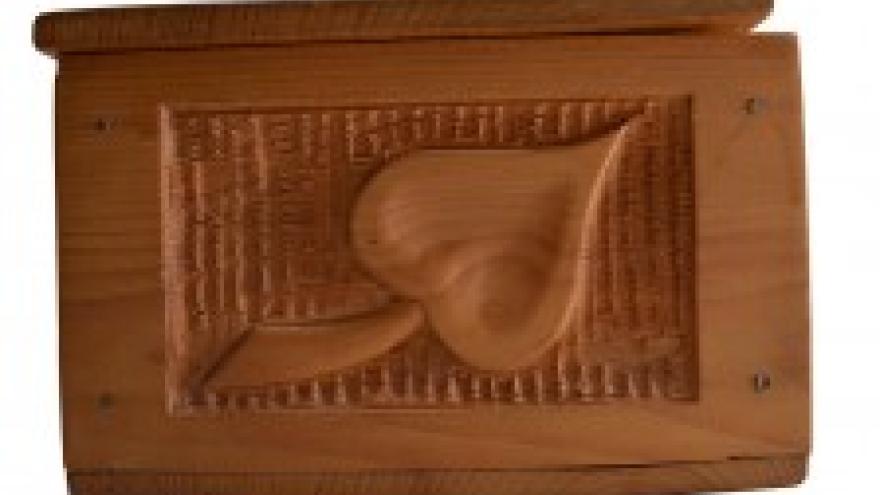 Carved wooden panel with a stylized leaf design.