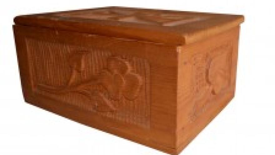 Wooden box with floral carvings on the sides and top.
