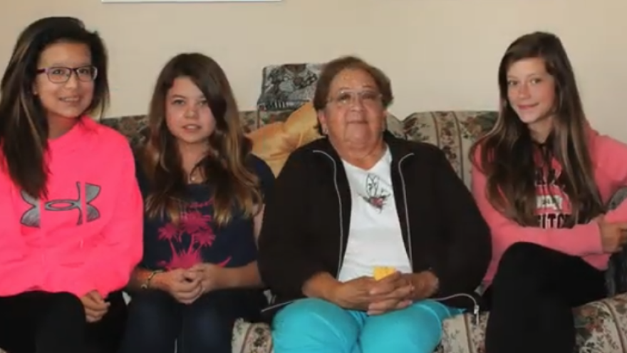 Four people sitting together on a couch, smiling warmly.