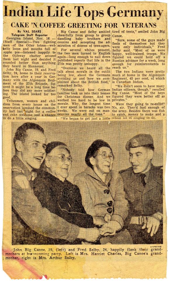 Four people smiling and sitting together in a vintage photograph.