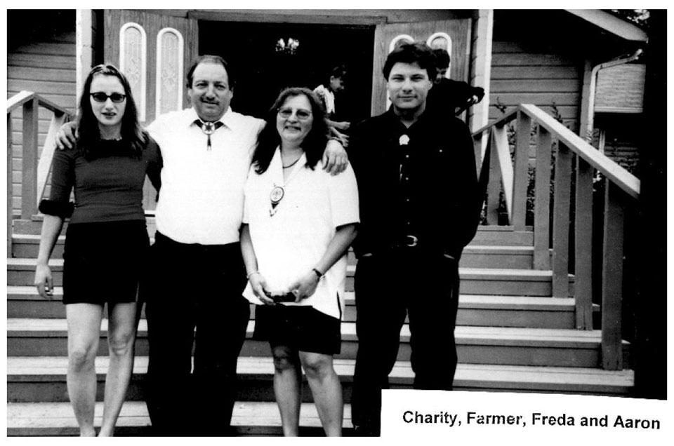 Black and white photo of four people standing on stairs.