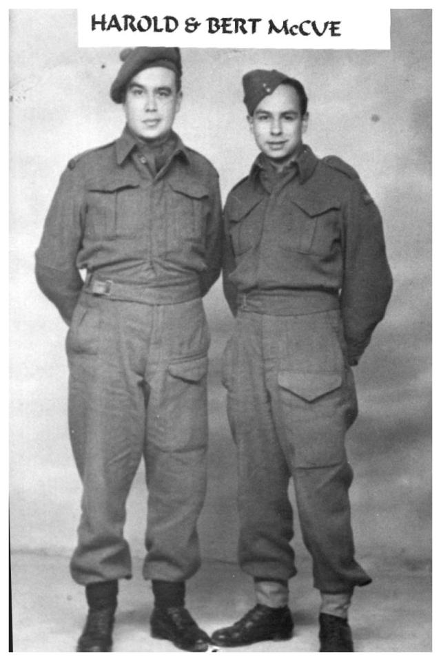 Two men in military uniforms stand side by side in a vintage photograph.