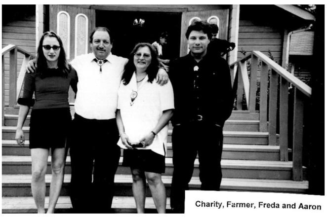 Black and white photo of four people standing on stairs.