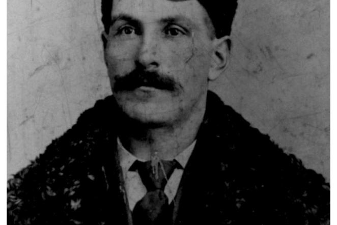 Black and white photo of a man with a mustache wearing a fur coat.