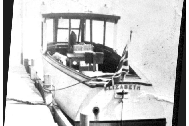 Black and white photo of a ferry boat docked at a pier.