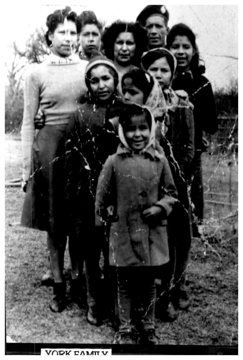 Nine people standing outdoors, several children in front. Black and white photograph.